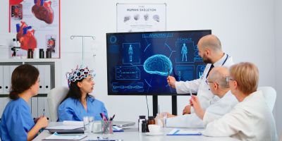 Group of specialist doctors analysing brain functions using high tech in medical boardroom, nurse testing new innovation. Medic studying diagnosis of patients working in hospital conference room